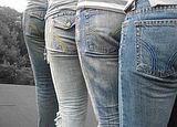 Close up of four rear ends in jeans
