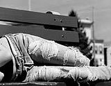Black and white phot of person laying on a bench in jeans